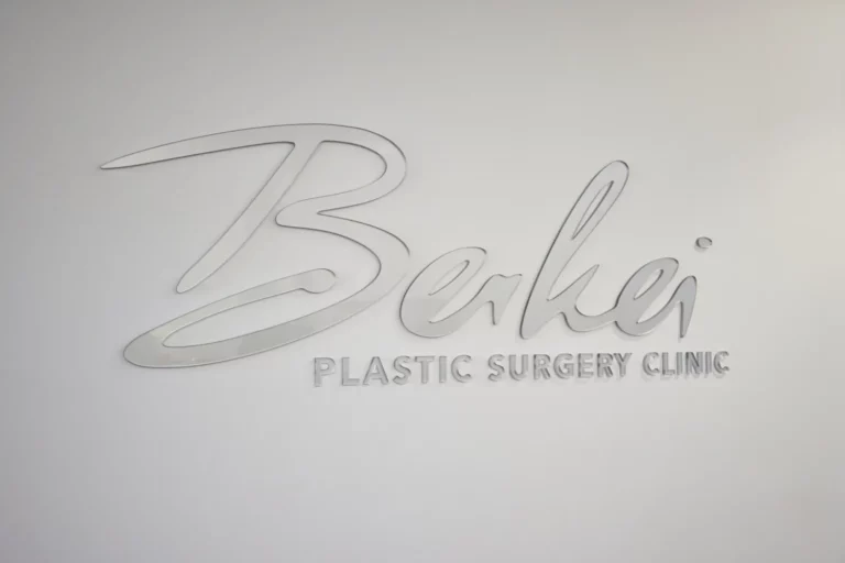 Silberner "Berkei Plastic Surgery Clinic" Schriftzug an einer Wand.