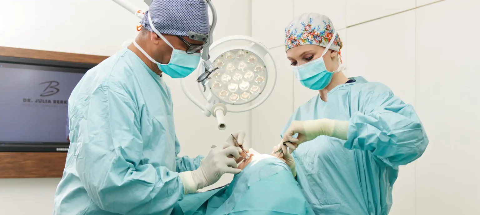 Aufnahme von Herr Elzebair und Dr. Tosun gemeinsam bei einer OP am Gesicht einer Patientin.