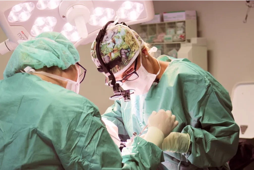 Aufnahme von Dr. Berkei und einer Kollegin konzentriert während einer OP am Gesicht.