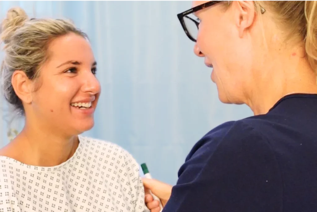 Aufnahme von Dr. Berkei und einer glücklichen Patientin im OP-Kittel kurz vor der OP.